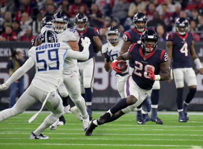 Texans running back Alfred Blue (28) runs around Titans inside linebacker Wesley Woodyard (59) during a 2018 game.